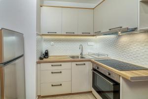 Una cocina con gabinetes blancos y un fregadero. en Quince city center, en Heraclión 11 fotos más