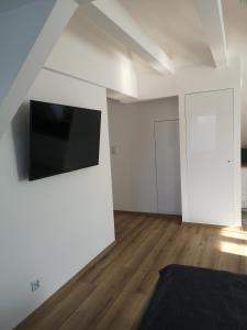 una sala de estar vacía con TV de pantalla plana en la pared en Apartamenty Lawendowy Zakątek 7, en Opole