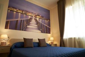 um quarto com uma cama azul com um quadro na parede em Le Stanze di Ricci - Affittacamere Low cost em Lesina