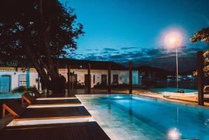 a swimming pool in front of a building at night at Passagem Concept Hotel e Spa in Cabo Frio