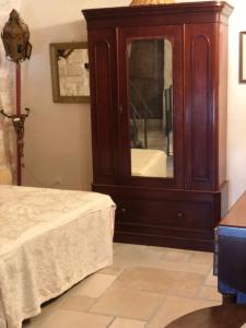 a bedroom with a large wooden cabinet with a mirror at Casa Federico in Ostuni