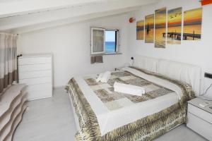 カステルサルドにあるResidence Auroraの大きなベッドと窓のある白い寝室