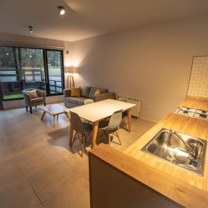 a kitchen and living room with a table and a couch at BOG Norway - Departamentos Céntricos in Villa La Angostura +40 photos
