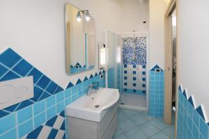 カステルサルドにあるResidence Auroraの青いタイル張りのバスルーム(シンク、鏡付) +34枚の写真