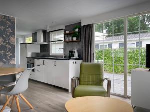 cocina y sala de estar con mesa y sillas en Chalet Natuurrijk, en Oisterwijk
