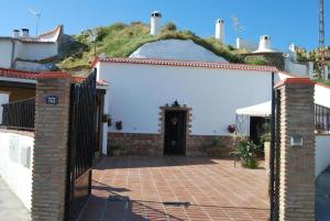 a gate to a house with a hill behind it at Cueva La Ermita in Guadix