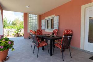 a dining room with a table and chairs at Sonja Vacation home in Podorjak
