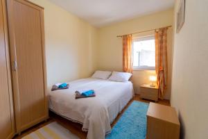 a bedroom with a bed with two towels on it at Sonja Vacation home in Podorjak