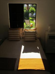 um quarto com uma janela com uma cama e uma cadeira em Go PT - Private challet with swimming pool and garden em Parede
