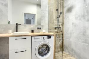 a bathroom with a washing machine and a shower at SuperApart Komputerowa 8 in Warsaw