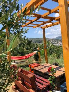 a bench and a hammock under a wooden pergola at Glass house in Ulcinj
