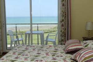 a bedroom with a bed and a view of the ocean at Hotel Royal Albion in Mesnil-Val-Plage