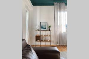 a living room with a couch and a window at Etern Stays - Bohemian Apartment in Pristina