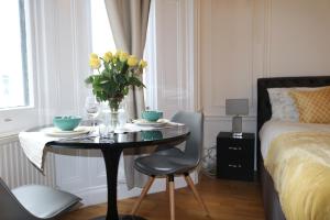 a bedroom with a table with a vase of flowers on it at The Courtfield Plaza in London