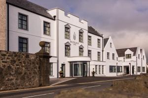 a white building with black windows on a street at Ballygally Castle in Larne