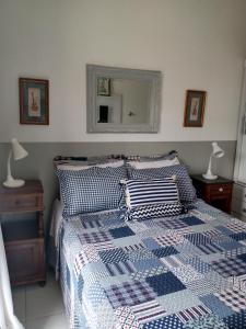 a bedroom with a bed with a blue and white comforter at Conheça Caxambu e sua Natureza in Caxambu