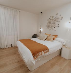 Habitación blanca con cama grande y lámpara de araña. en OH MY HOME BILBAO, en Bilbao