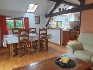 a kitchen and living room with a table and chairs at La GRANGE de MOMBEL in Losse +65 photos