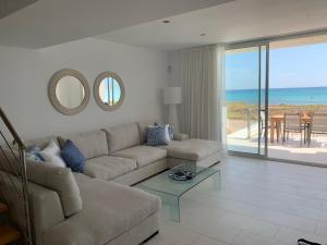 a living room with a couch and a view of the ocean at Son Serra Sea Coast Villa in Son Serra de Marina