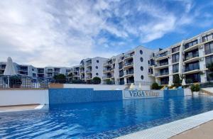 a swimming pool in front of some apartment buildings at Vega Village Ap A8 in Sveti Vlas +14 photos