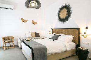 a bedroom with a large white bed and a chair at studio lefkes kea in Vourkari