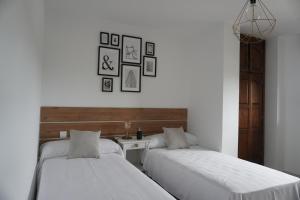 dwa łóżka ustawione obok siebie w pokoju w obiekcie Hostal La Biela 43 w mieście Galizano +18 zdjęć