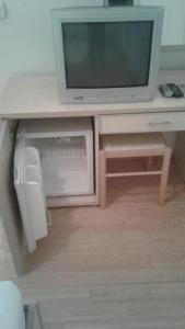a tv sitting on a desk with a table with a tv at BMV TRIPLE ROOM WITH BALCONY in Sveti Stefan +15 photos