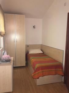 a small bedroom with a bed and a cabinet at BMV TRIPLE ROOM WITH BALCONY in Sveti Stefan