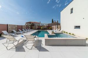patio z krzesłami i basenem w obiekcie PINNA RESIDENCE - Datul w Puli