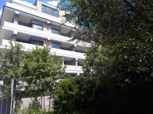 a white building with trees in front of it at Apartmán U Parku in Hodonín