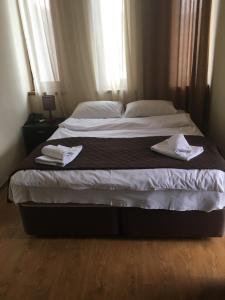a bedroom with a large bed with towels on it at Hotel Victoria-Panorama in Borjomi