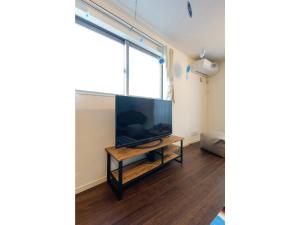 una sala de estar con una gran TV de pantalla plana en una mesa en rakuna Inn Dou-sasazuka - Vacation STAY 47231v, en Tokio