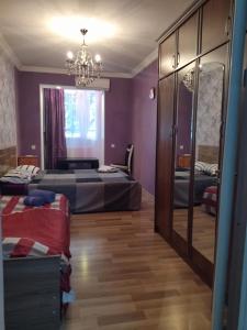 a purple bedroom with two beds and a chandelier at Apartment for you in Tbilisi City