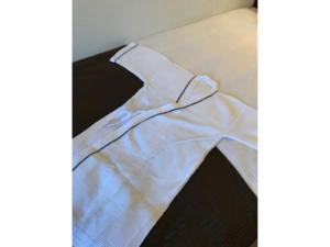 una camisa blanca con una corbata de moño en un sofá en Sky Heart Hotel Koiwa - Vacation STAY 49106v, en Tokio