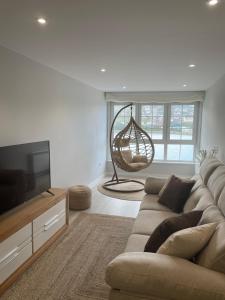 a living room with a couch and a flat screen tv at Golden Views in Viveiro