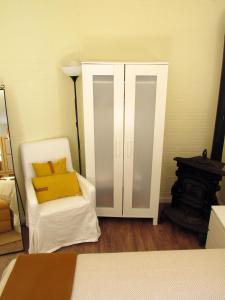a bedroom with a white cabinet and a white chair at Go PT - Private challet with swimming pool and garden in Parede