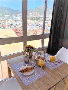 a table with a plate of food and two glasses of orange juice at Agata Beach in Benalmádena