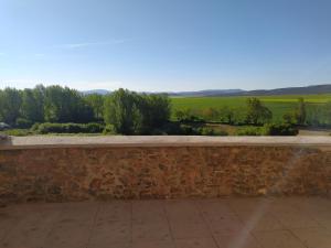 a stone retaining wall with a view of a field at Casa Bécquer in Noviercas