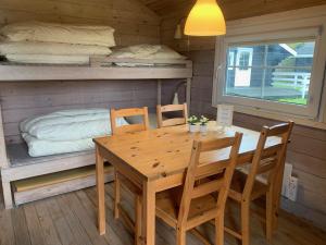 a dining room with a table and chairs and a bed at Løkken Family Camping & Guesthouse in Løkken +32 photos