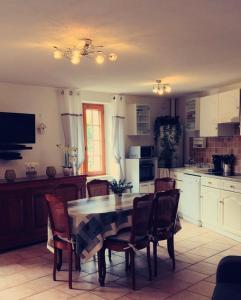 a kitchen with a table and chairs and a kitchen with white cabinets at Gite Les Ours in Chémery