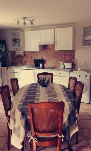 a kitchen with a table with chairs and a tableablish at Gite Les Ours in Chémery