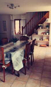 a dining room with a table and chairs and a staircase at Gite Les Ours in Chémery