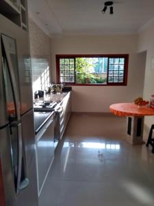 a kitchen with a stove and a table in it at Vila do Aconchego in Ubatuba