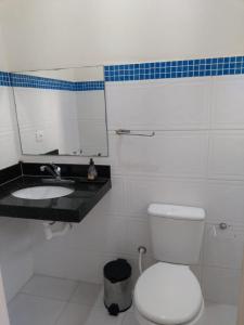 a bathroom with a white toilet and a sink at Vila do Aconchego in Ubatuba +17 photos