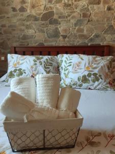 a basket of pillows sitting on top of a bed at Apartamentos Callampa in Torrejón el Rubio