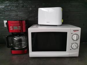 a microwave with a coffee maker on top of it at Traian Apartment - Cluj in Cluj-Napoca