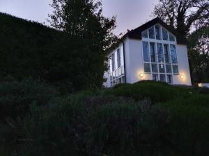 a house with lights on the side of a hill at Ferienhaus Grabowblick in Barth