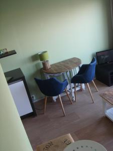 een woonkamer met een tafel en twee blauwe stoelen bij Luxe Strandhuisje op het strand van Wijk aan Zee met wifi in Wijk aan Zee