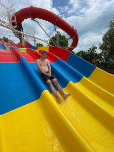 a man sitting on a slide at a water park at Pelso Camping in Alsóörs