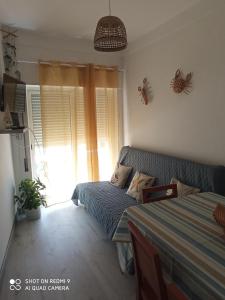 Habitación pequeña con cama y ventana en CASA do BATORÉU - BUARCOS 120 MT PRAIA, en Figueira da Foz